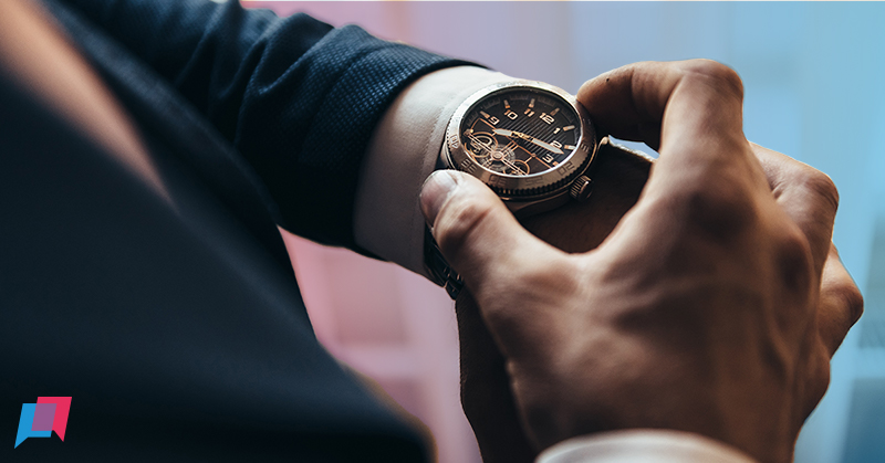 man kijkt op horloge